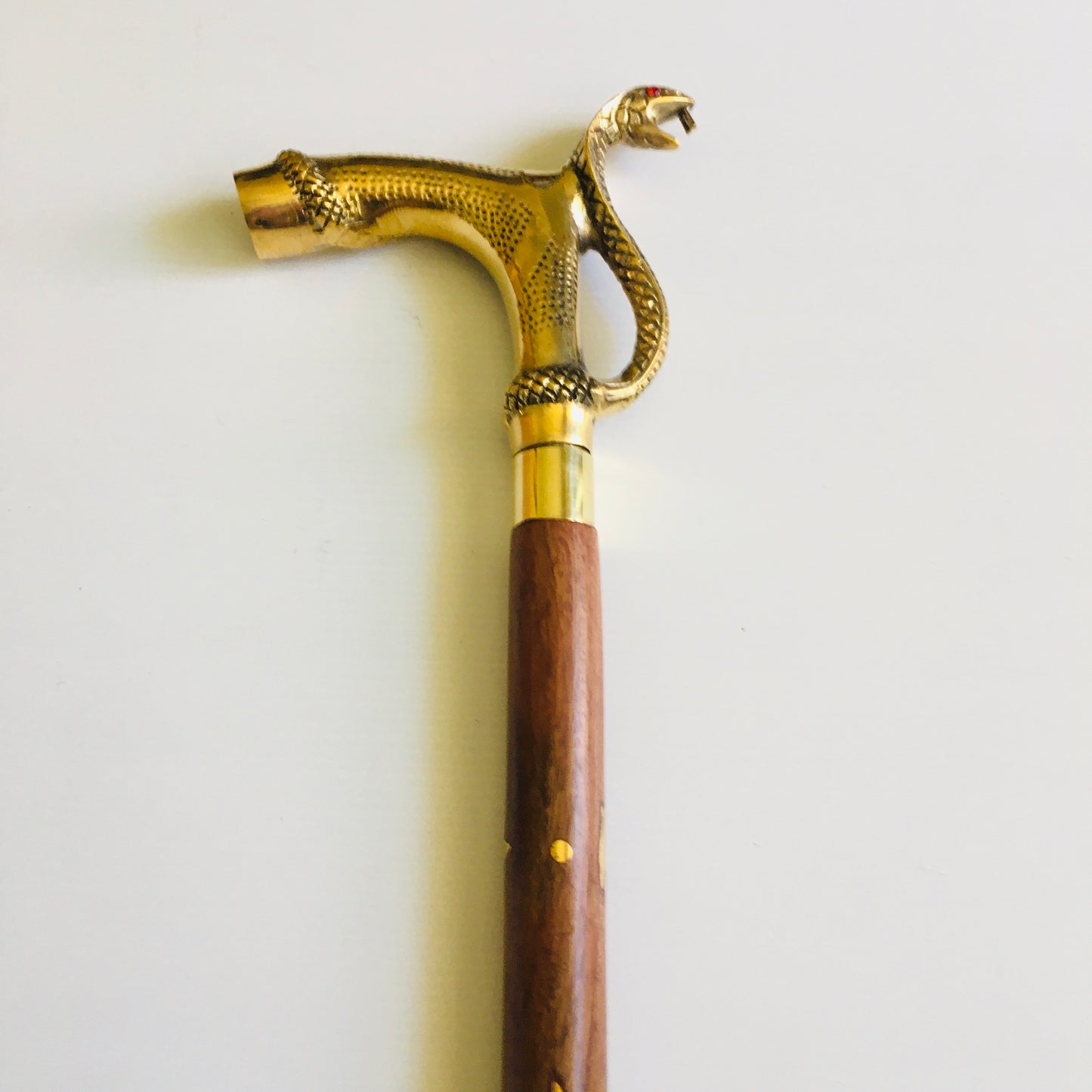 Walking Stick with Large Snakes Head Brass Handle on Brown Stick with brass inlay.