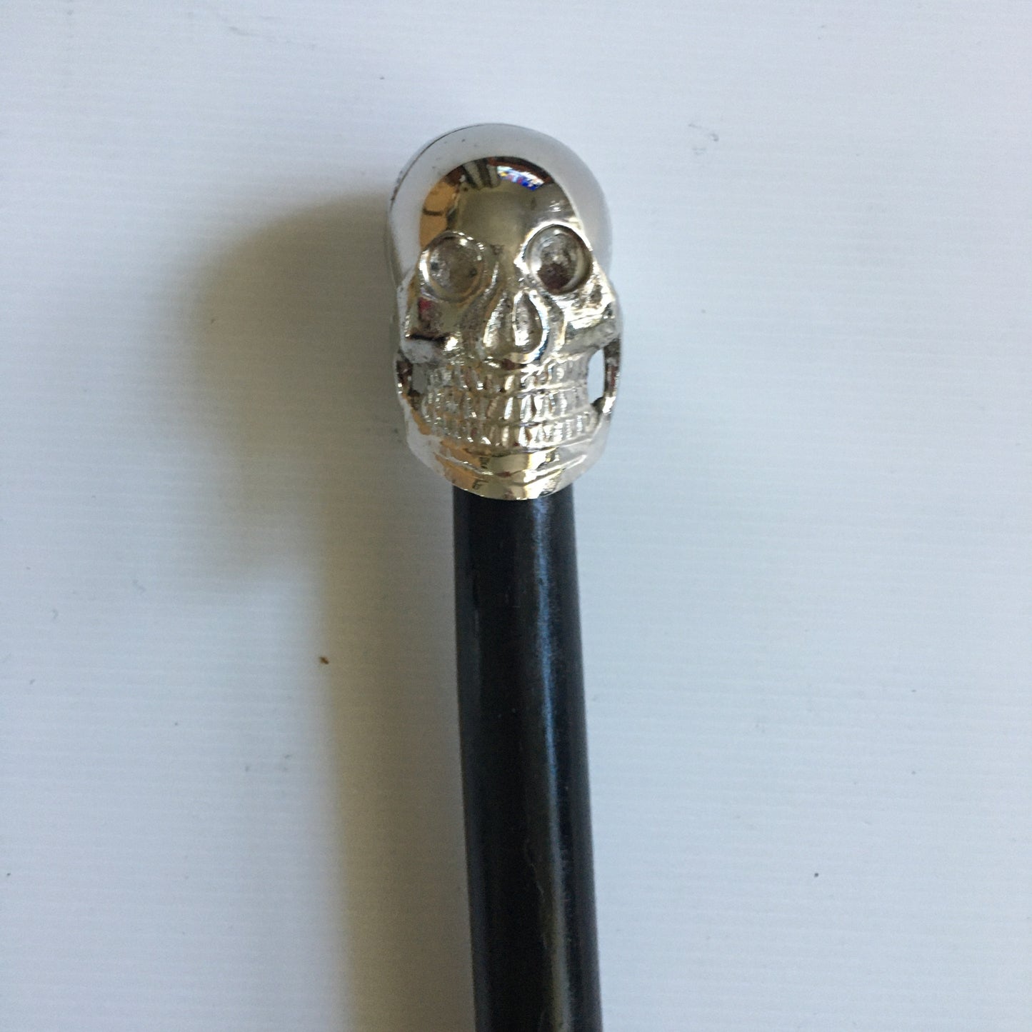 Walking Stick with Silver Skull design Handle on a Plain black stick or turned wood stick.