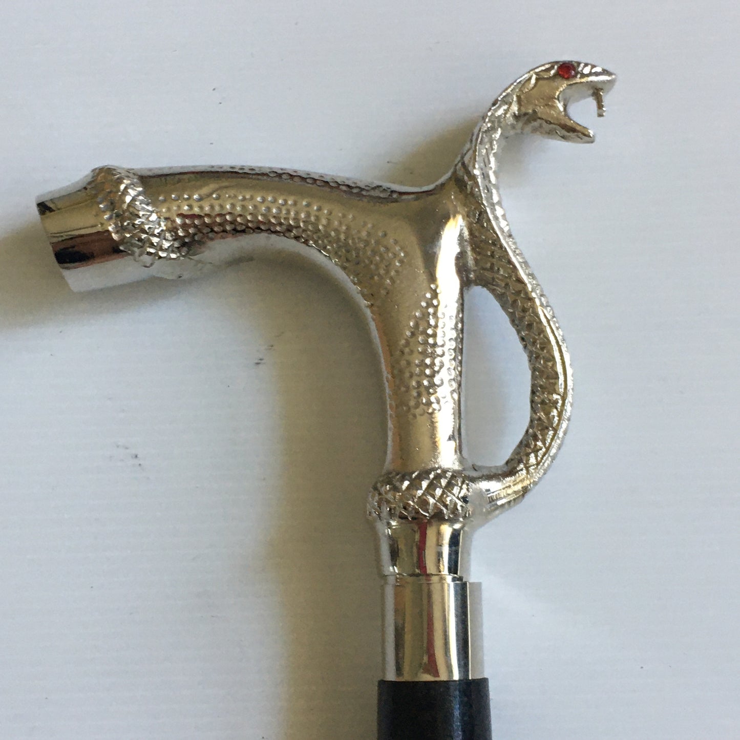Walking Stick with Silver Snakes Head Handle on a black stick with brass inlay.