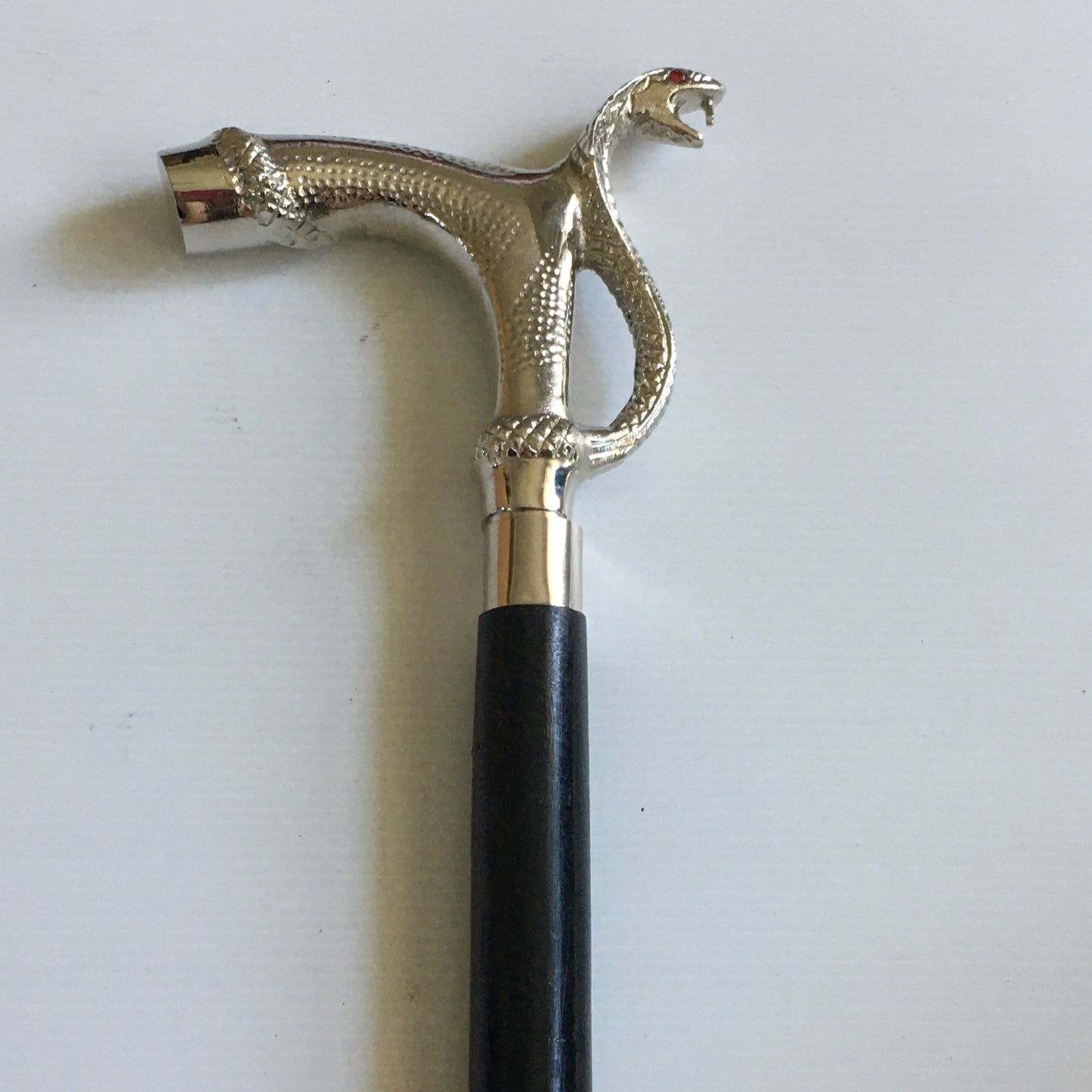 Walking Stick with Silver Snakes Head Handle on a black stick with brass inlay.