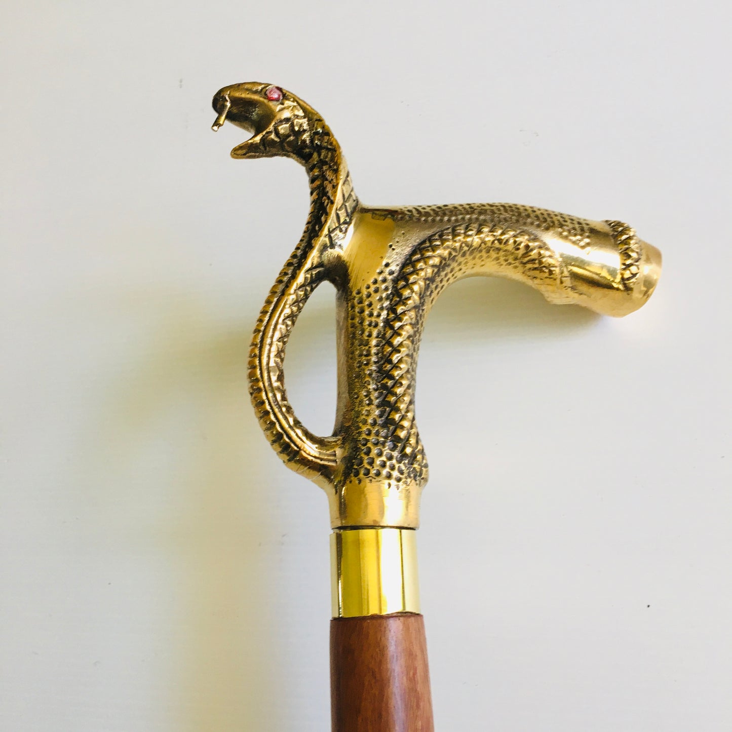 Walking Stick with Large Snakes Head Brass Handle on Brown Stick with brass inlay.