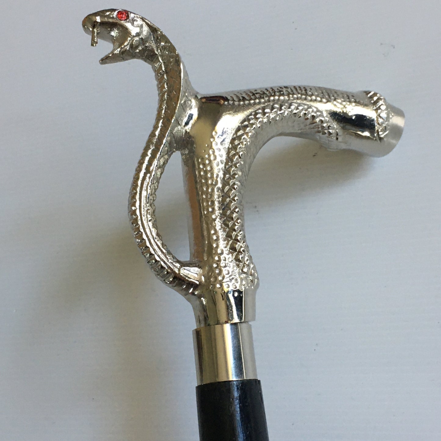 Walking Stick with Silver Snakes Head Handle on a black stick with brass inlay.